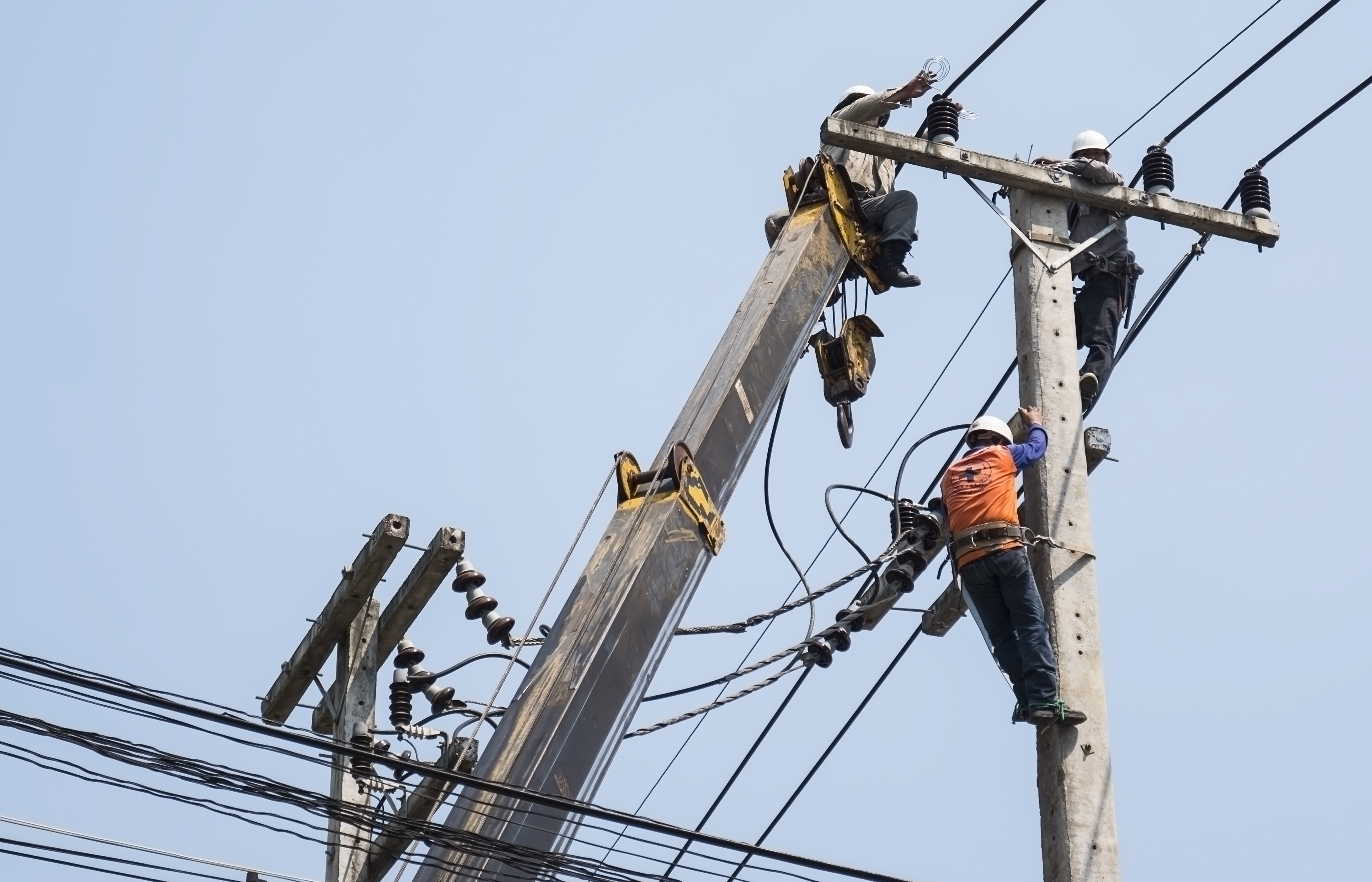 Utility crew performing overhead power line installation